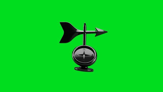 A black weather vane with a compass base isolated against a green background