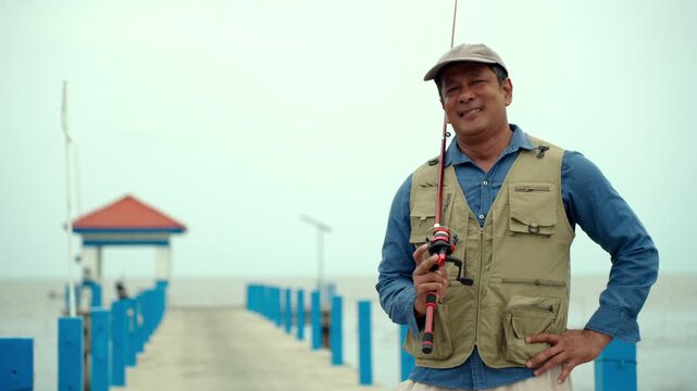Portrait Senior man preparing fishing gear by the seaside. Retirement lifestyle active aging. Healthy longevity, outdoor recreation, peaceful leisure. Life insurance planning for a secure retirement.
