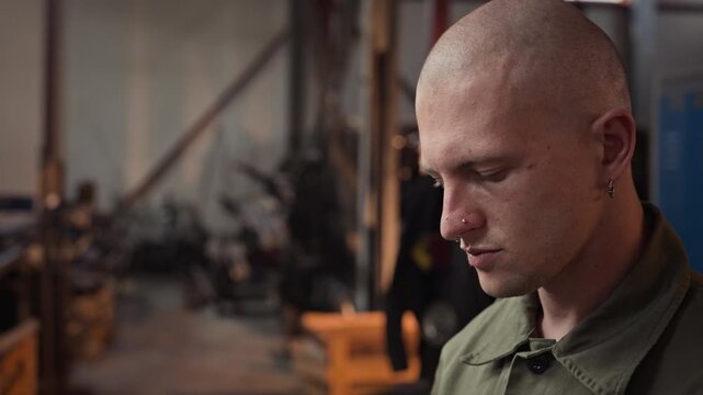 Young adult Caucasian male welder taking off protective mask and wiping sweat from forehead in close up tilt up shot. Video is perfect for industrial safety or manufacturing recruitment
