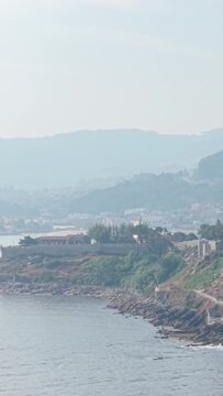 Vertical 9:16 video showing the rocky coastline and historic stone walls of Castelo de Monterreal in Baiona, Spain.