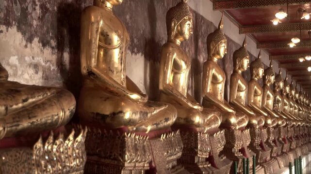 Row of ancient buddha statues in buddhist temple
