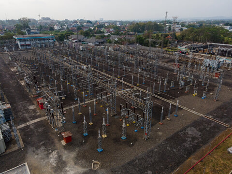 Aerial view of an electrical substation with high-voltage equipment and metal structures in Purwokerto Selatan, Central Java, Indonesia.