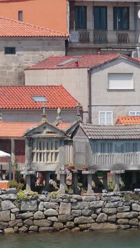 Vertical 9:16 video of iconic stone horreos (traditional Galician granaries) on the waterfront in Combarro, Spain.