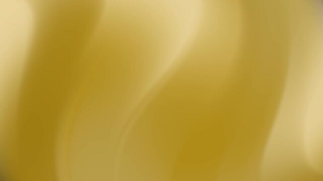 Gold gradient shimmers on abstract blurred surface resembling a luxurious silk fabric texture.