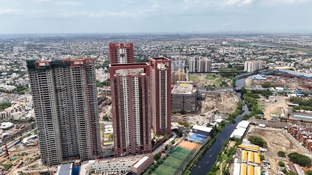 Aerial view of the SPR City Binny residential complex featuring tall modern skyscrapers, surrounding urban development, and a nearby canal in Chennai, Tamil Nadu, India.