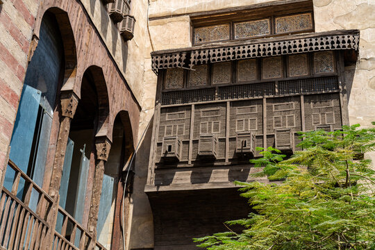 View of intricate wooden mashrabiya screen on the historic facade of the Mosque and Madrasa of Umm al-Sultan Sha'ban with detailed geometric carvings in Cairo, Cairo Governorate, Egypt.