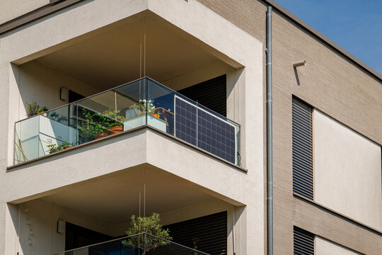Solar panels on a balcony of a modern apartment building in a city during the day
