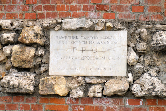 Historic memorial plaque marking early nineteenth century Grotto in the Alexander Garden architecture, mounted on an ancient brick and stone wall - Moscow, Russia, August 11, 2026