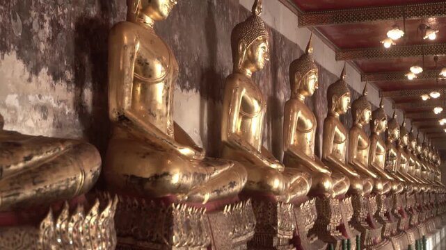 Row of ancient buddha statues in buddhist temple