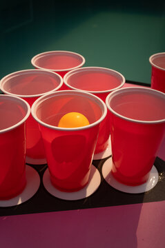 Red beer pong cups with orange ping pong ball