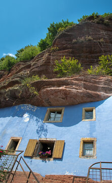 Historische Felsenh&auml;user von Graufthal. Blaue Fassaden der Halbh&ouml;hlenwohnungen, eingebaut in die rosa Sandsteinwand, Detail