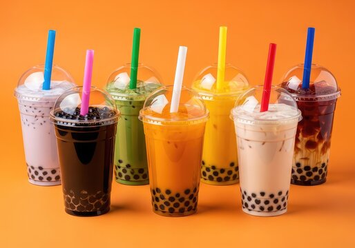 Assorted colorful bubble tea flavors with black tapioca pearls in plastic cups with straws, arranged on a vibrant orange summer background, sweet, liquid, style