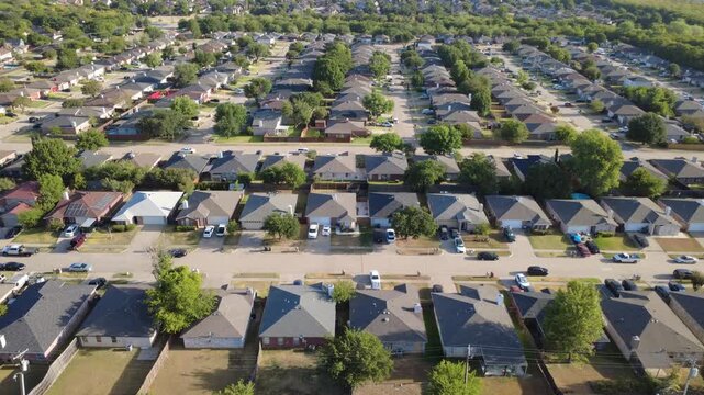Parallel asphalt driveways cross through Charles City neighborhood properties. Single story brick homes line peaceful community avenues beneath sunny North Texas skies, Arlington