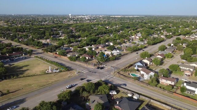 Wide painted crosswalks anchor intersection of East Sublett Road, Southeast Parkway. Expansive grassy corner parcels border dense single family residential developments, Arlington, Texas