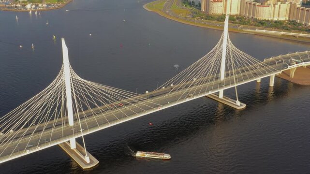 Aerial view of the cable-stayed Western High-Speed Diameter bridge spanning the water with a boat passing underneath in Saint Petersburg, Saint Petersburg, Russia.