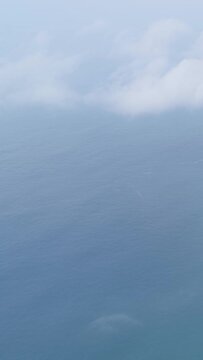 A vertical 9:16 video clip showing a misty view over the Atlantic Ocean from the cliffs near Garita da Herbeira in Meizoso, Spain.
