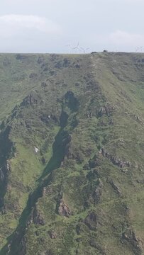 Vertical 9:16 aerial video showcasing the dramatic green cliffs and rugged terrain around Garita da Herbeira near Meizoso, Spain.