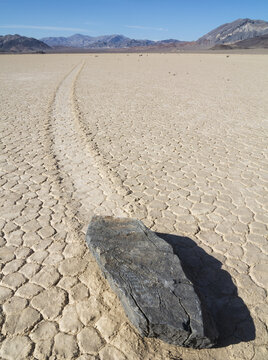 View of a sliding rock with a long trail on the cracked mud surface of Racetrack Playa in Death Valley, California, United States.