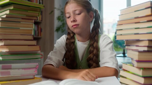 Fatigued suffering Caucasian little girl school child with many books overloaded overwhelmed with study process studying difficulties tired kid daughter learning hard trouble schoolwork learn stress