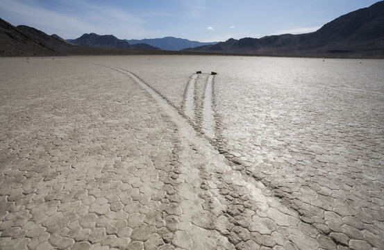 View of Racetrack Playa with sliding stones and their long trails on the cracked desert floor in Death Valley, California, United States.