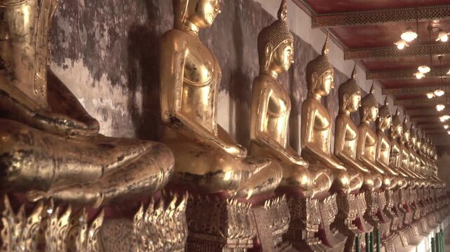 Row of ancient buddha statues in buddhist temple