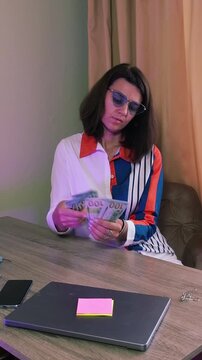 Counting money at home while sitting at a desk in the evening