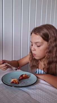 Girl enjoys dessert while sitting at a table in a bright room during the afternoon