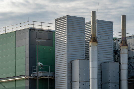 View of the modern data center facility with industrial ventilation towers, green and grey metal cladding, and a security camera in Middenmeer, North Holland, Netherlands.