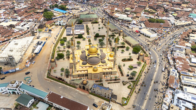 Aerial view of Ilorin Central Mosque with its golden domes and minarets, surrounded by the dense urban landscape and bustling streets of Oko Erin, Kwara, Nigeria.