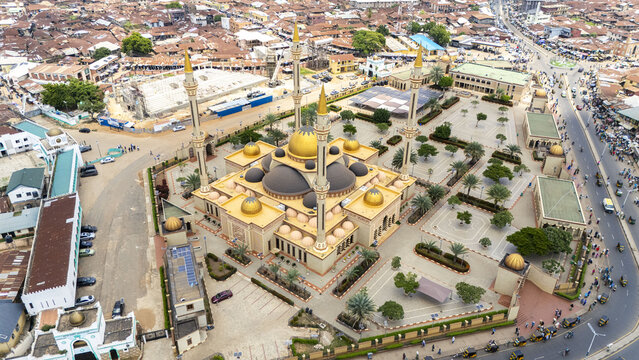 Aerial view of Ilorin Central Mosque with its golden domes and minarets surrounded by the urban landscape of Oko Erin, Kwara, Nigeria.