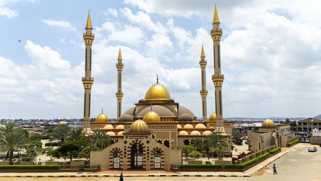 Aerial view of Ilorin Central Mosque with its prominent golden domes and tall minarets, surrounded by lush trees and urban surroundings in Oko Erin, Kwara, Nigeria.