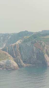 Vertical 9:16 video showing dramatic rocky cliffs and the rugged coastline at the edge of El Peine del Mar near Cudillero, Asturias, Spain.