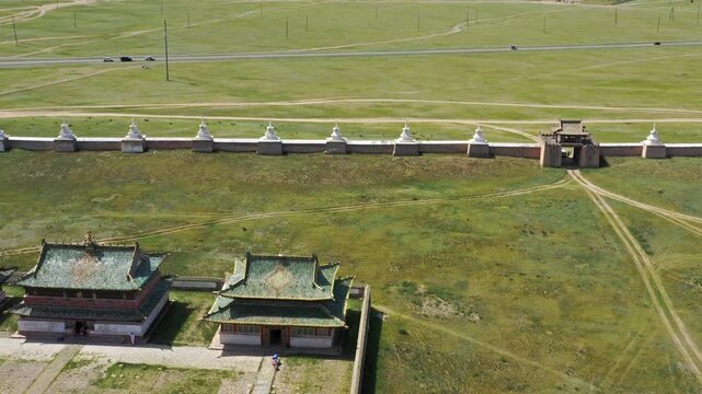 Aerial view of the historic Erdene Zuu Monastery with its iconic white stupas along the perimeter wall, set against the vast green Mongolian steppe in Kharkhorin, Ovorkhangai, Mongolia.