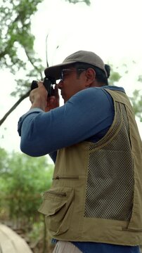Experienced senior male photographer capturing the beauty of nature in a forest. Active aging creative retirement, outdoor photography, lifelong passion, healthy longevity and fulfilling lifestyle.
