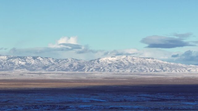 Aerial view of the snow-capped mountains and vast desert landscape of the Morley Nelson Snake River Birds of Prey National Conservation Area in Murphy, Idaho, United States.