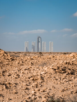 View of the modern skyscrapers of New Alamein City rising above the arid, rocky desert landscape in Al Alameen City, Marsa Matrouh Governo, Egypt.