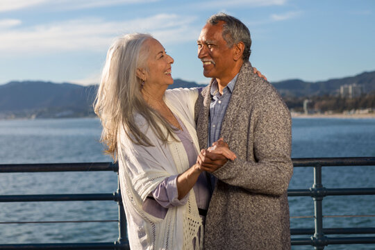 Elderly couple dancing joyfully outdoors