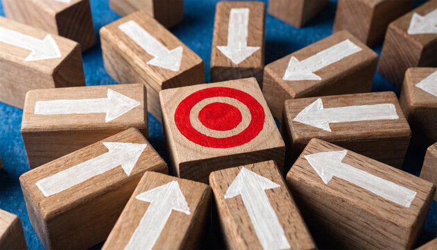 Target concept, wooden blocks with white arrows pointing to red bullseye, focus and strategy