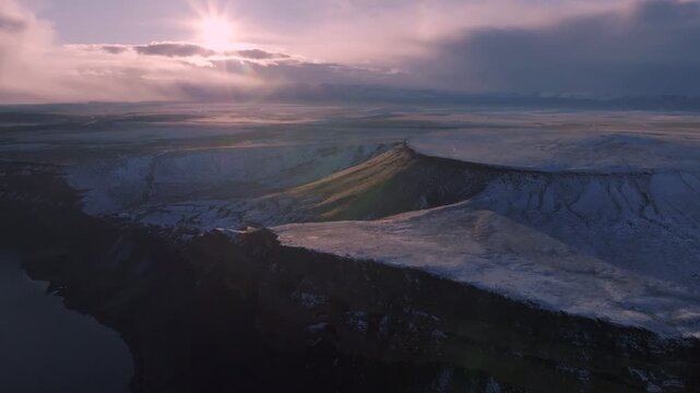 Aerial view of Morley Nelson Snake River Birds of Prey National Conservation Area featuring snow-dusted cliffs and plateaus under a soft sunset sky in Murphy, Idaho, United States.