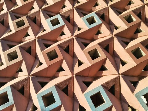 Pastel geometric concrete breeze block wall texture with deep shadows