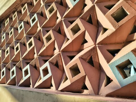 Pastel geometric concrete breeze block wall texture with deep shadows