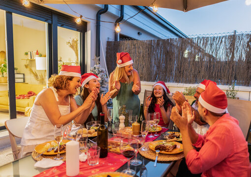 Happy family and friends celebrating christmas dinner on terrace