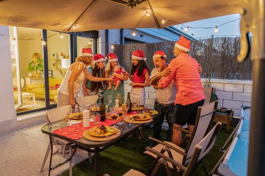 Family celebrating christmas with baby outdoors at night