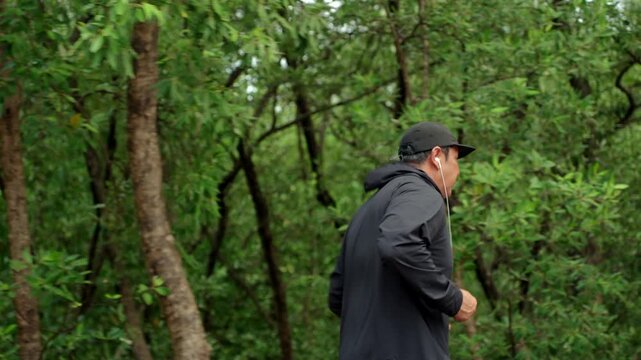 Happy active senior man jogging in nature after retirement. Healthy aging, fitness. Longevity outdoor lifestyle, preventive health, retirement happiness. Life insurance and financial security concept.