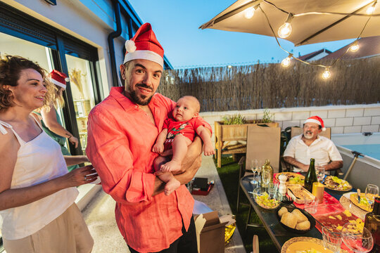 Father holding baby celebrating christmas eve with family