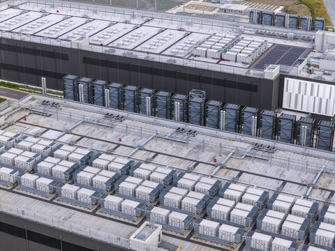 Aerial view of a large industrial data center facility featuring rows of cooling units on the roof in Drogheda, County Louth, Ireland.
