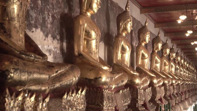 Row of ancient buddha statues in buddhist temple