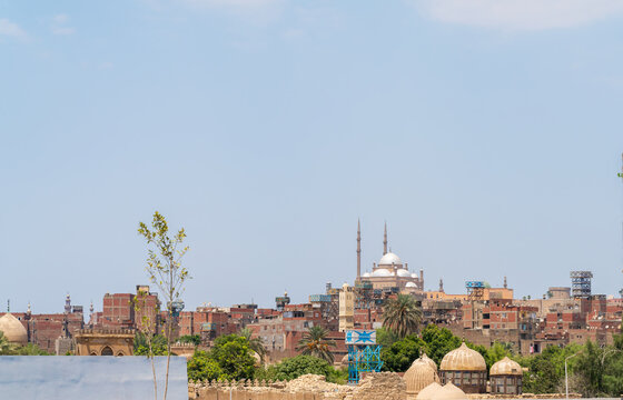 View of the historic Cairo Citadel with its prominent domes and minarets rising above the dense urban landscape of Cairo, Egypt.