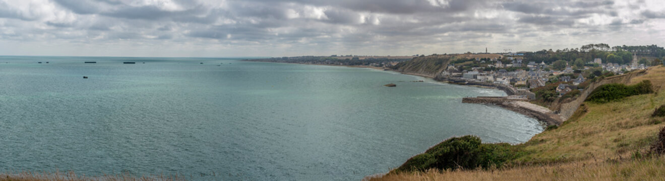 Arromanches-les-Bains, France - 08 10 2026:  Normandy landing blockhouse. Panoramic view of the artificial port with pontoons bridges, the beach, the sea, cliffs and the city from coastal path
