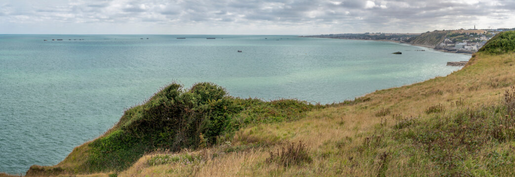 Arromanches-les-Bains, France - 08 10 2026:  Normandy landing blockhouse. Panoramic view of the artificial port with pontoons bridges, the beach, the sea, cliffs and the city from coastal path
